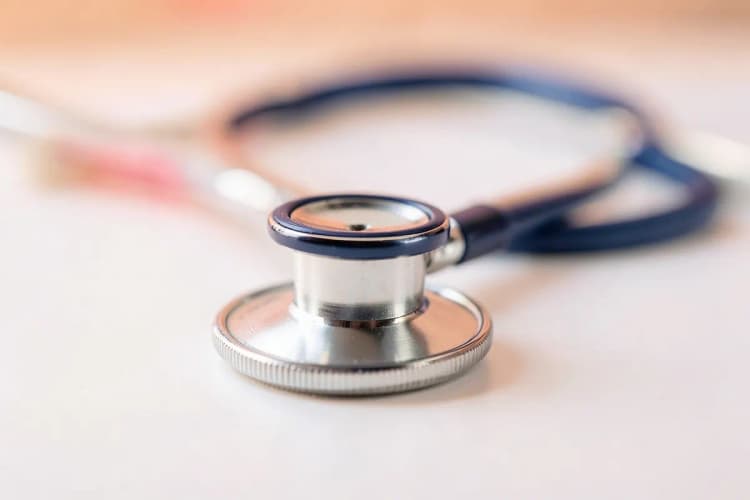 Close-up de um estetoscópio sobre um fundo branco, simbolizando diagnóstico médico