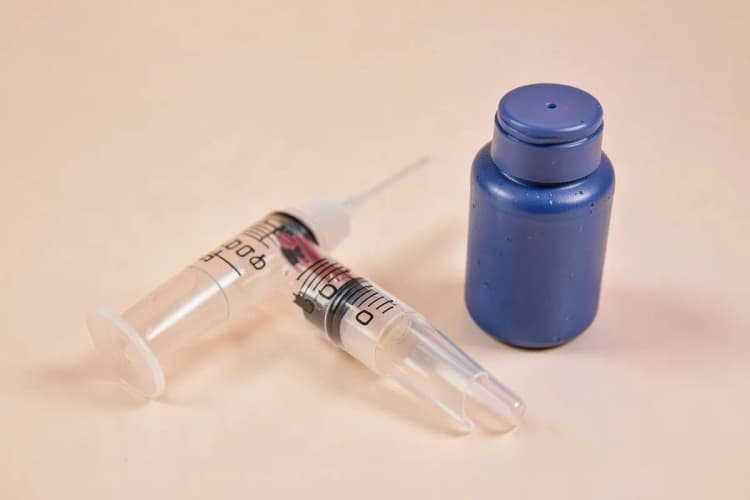 Um kit de lavagem nasal com seringa, frasco e bico em uma superfície limpa.