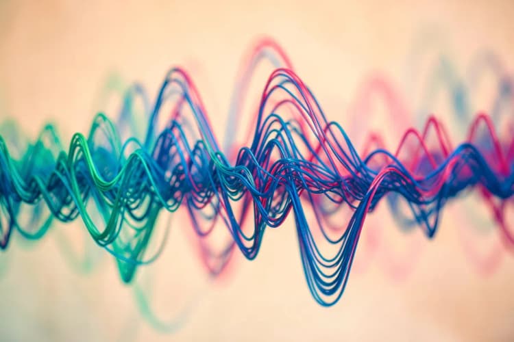 Ondas sonoras abstratas em tons de azul e verde, representando a percepção auditiva.