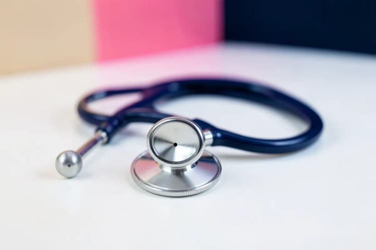 Um estetoscópio sobre um fundo branco, representando o diagnóstico médico.