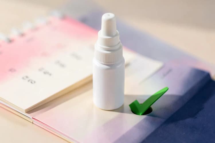 Frasco de spray nasal ao lado de um calendário e um símbolo de 'check'.